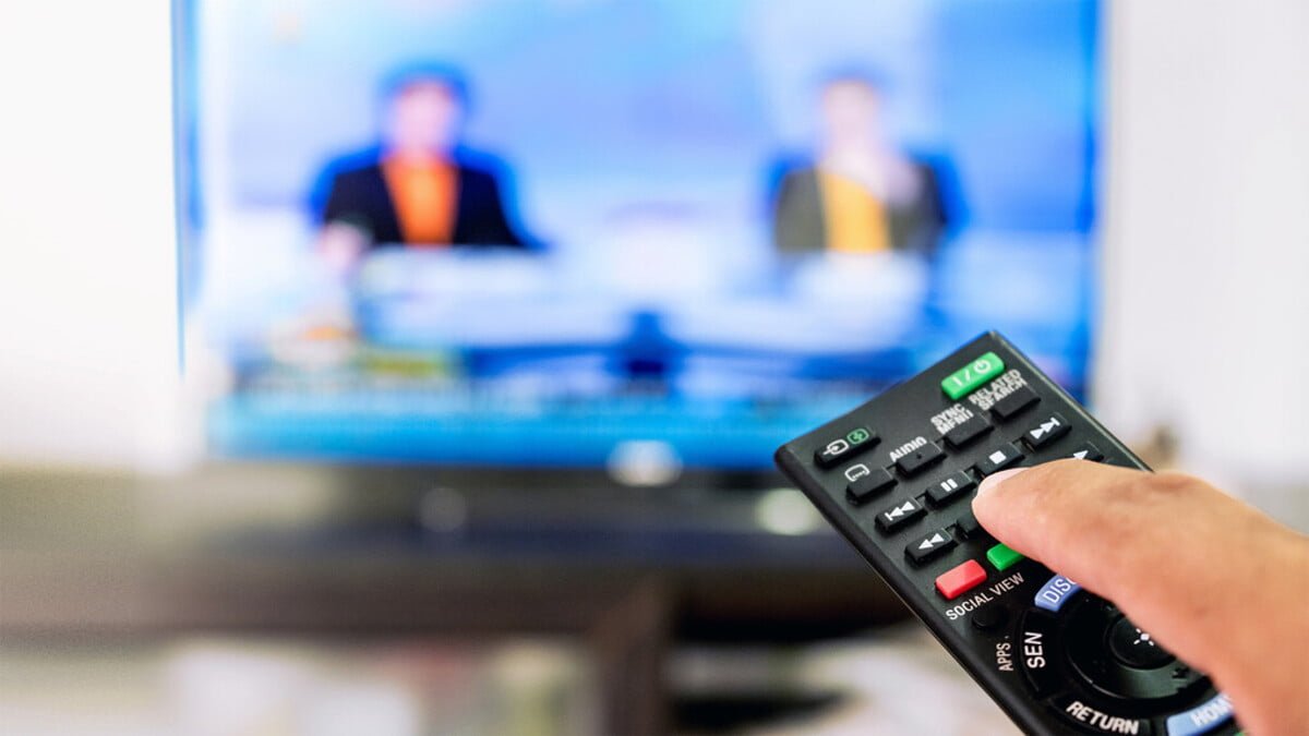 A photo of a remote controlling a blurred TV