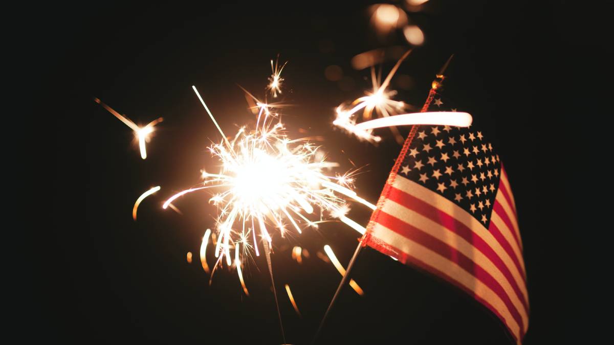 A photo of the American flag next to a lit sparkler