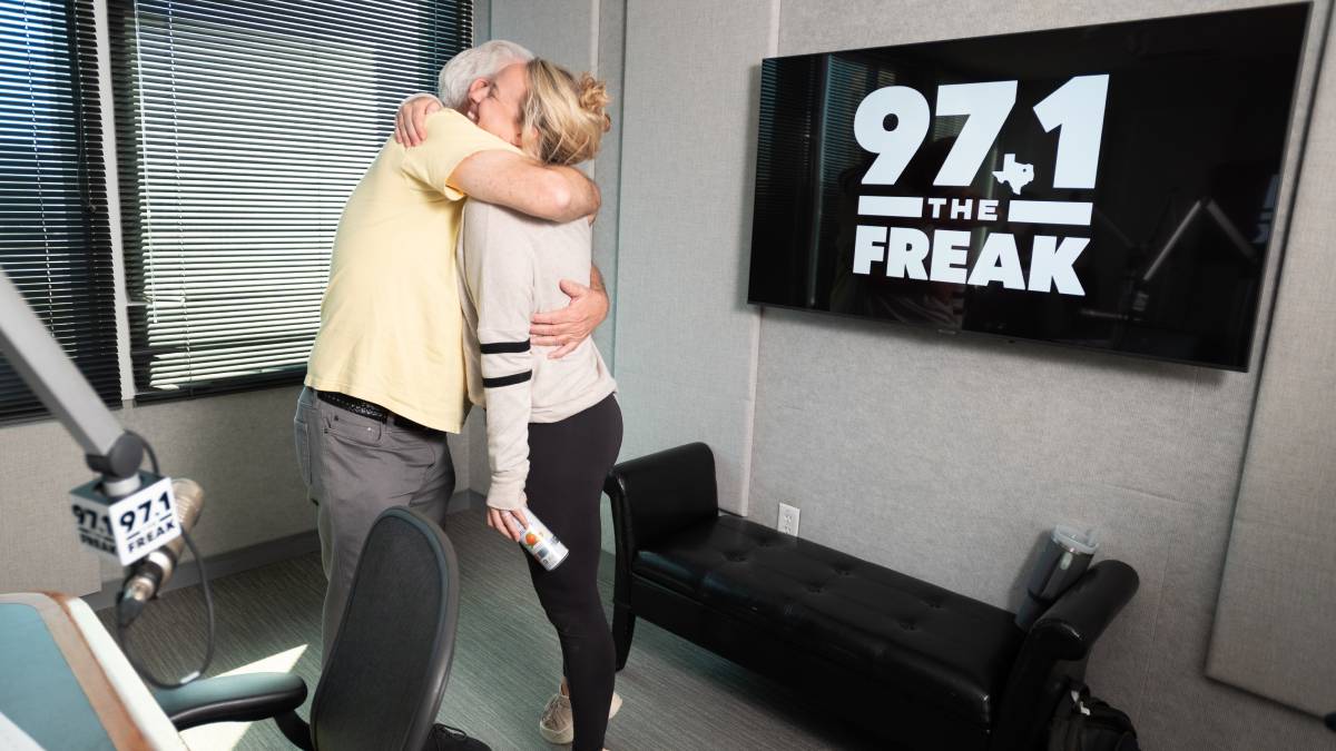 A photo of the 97.1 The Freak and two people hugging